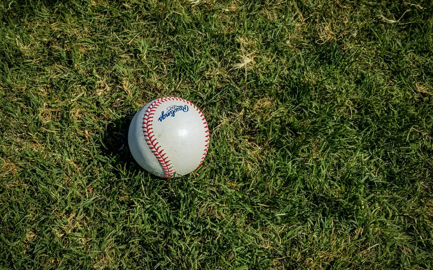 white and red baseball on green grass by Mick Haupt courtesy of Unsplash.