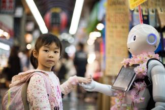 photo of girl laying left hand on white digital robot by Andy Kelly courtesy of Unsplash.