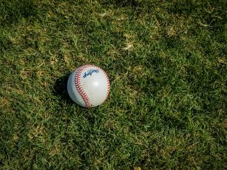 white and red baseball on green grass by Mick Haupt courtesy of Unsplash.