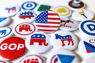 A pile of political buttons sitting on top of a table by Marek Studzinski courtesy of Unsplash.