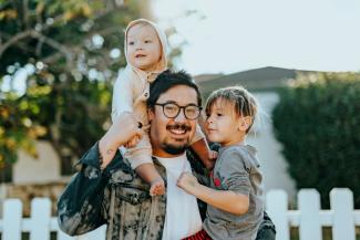 man in white shirt carrying girl in gray shirt by Nathan Dumlao courtesy of Unsplash.