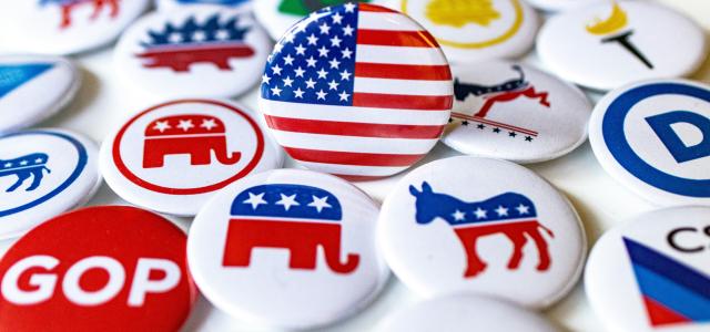 A pile of political buttons sitting on top of a table by Marek Studzinski courtesy of Unsplash.